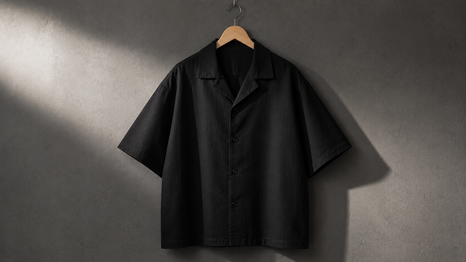 Schwarzes Oversize Hemd im Boxy Fit auf Bügel, kastige Silhouette von vorn
