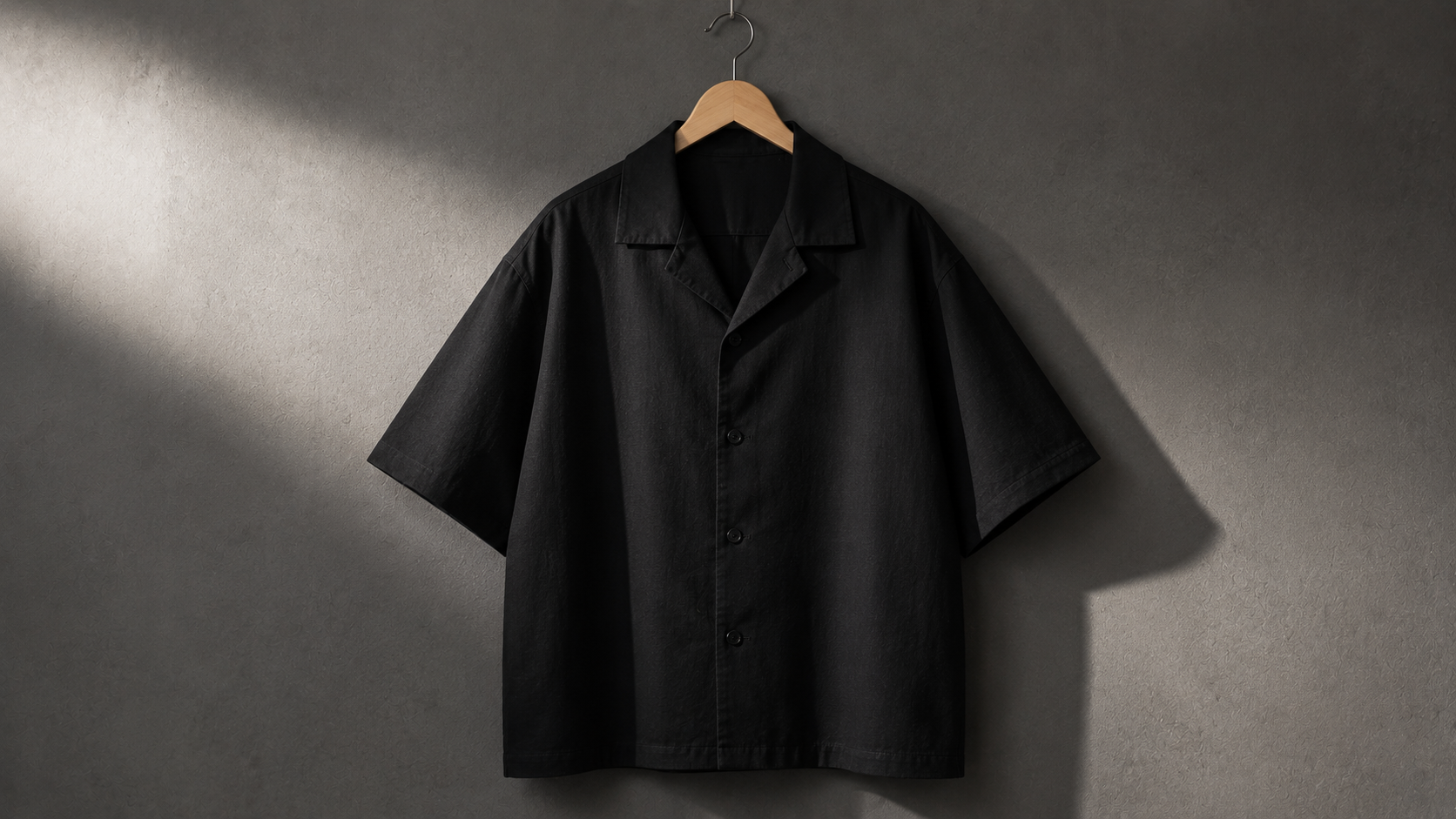 Schwarzes Oversize Hemd im Boxy Fit auf Bügel, kastige Silhouette von vorn