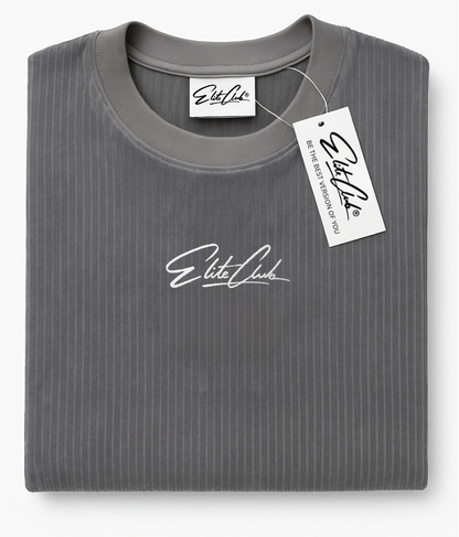 Gefaltetes Elite Club® Oversize Cord T-Shirt in Grau mit gesticktem Logo auf der Brust und Labelanhänger – modernes, minimalistisches Streetwear-Design.